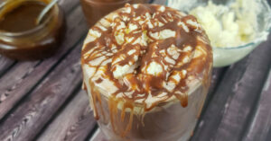Homemade hot chocolate topped with whipped cream and caramel sauce.