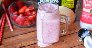 Strawberry milkshake dripping down the side of the jar it's served in.