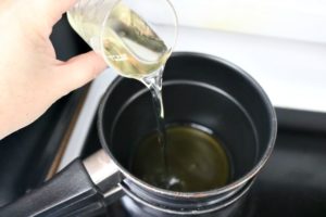 Adding oil to beeswax in double boiler