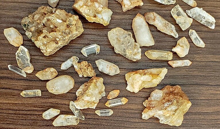 Iron stained quartz crystals on a wood table.