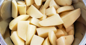 Quartered russet potatoes and water in Instant Pot.